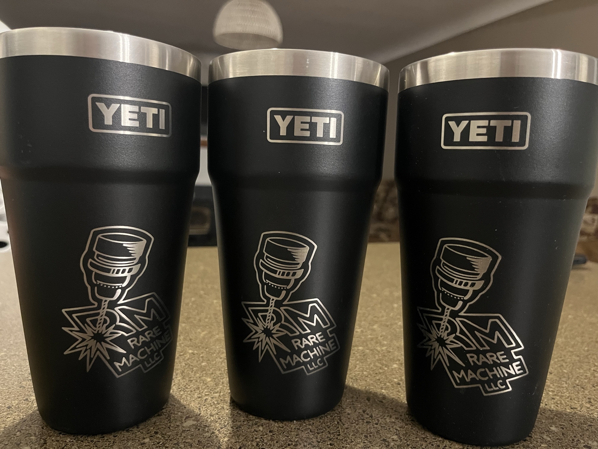 Three YETI tumblers laser-engraved with the Rare Machine LLC logo